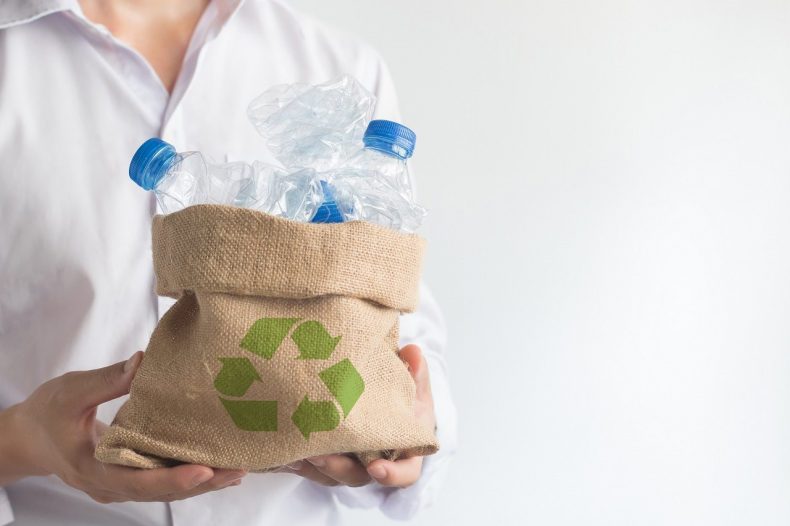 Hand holding sack bag with garbage recycle plastic bottles, Global warming solution, Environment concept