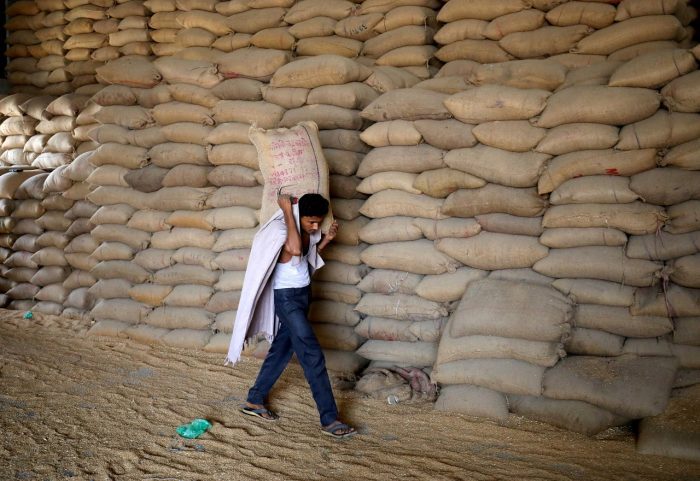 Foto de archivo de un trabajador cargando un saco de trigo en un molino en las afueras de Ahmedabad, India